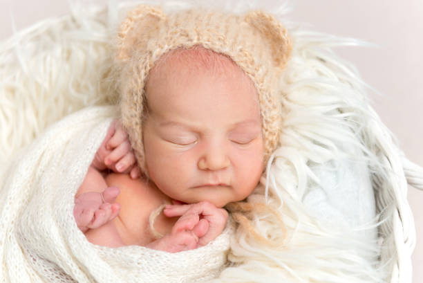 istock Newborn baby in funny bonnet napping in basket 1406797651