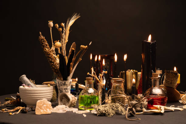 istock Witchcraft still life with black burning candles selective focus. Esoteric gothic and occult witch table for Halloween. Various magic objects and ritual arrangement. Gothic Halloween. 1406812381