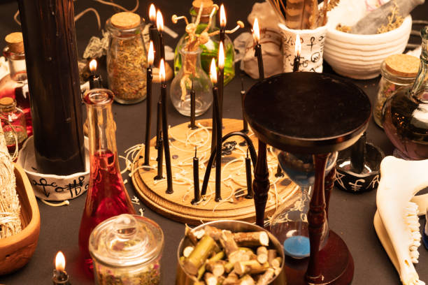 istock Witchcraft still life with black burning candles selective focus. Esoteric gothic and occult witch table for Halloween. Various magic objects and ritual arrangement. Gothic Halloween. 1406812391