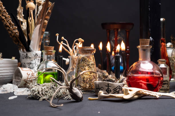 istock Witchcraft still life with black burning candles selective focus. Esoteric gothic and occult witch table for Halloween. Various magic objects and ritual arrangement. Gothic Halloween. 1406812394