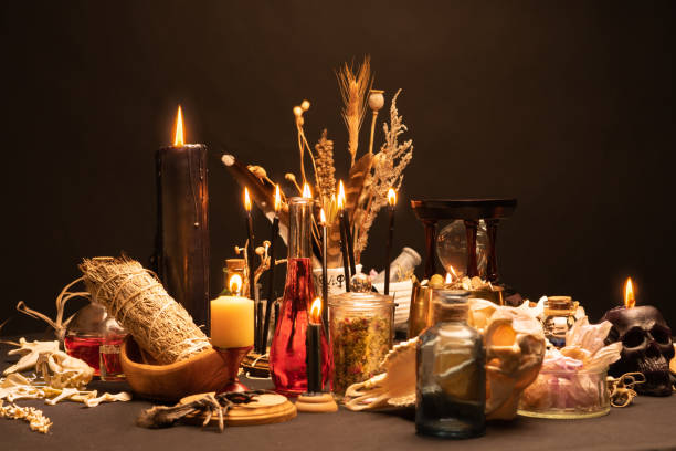 istock Occult and esoteric witch doctor still life. Selective focus. Halloween background with magic objects. Black candles skull, crystal stones, and potions vials on witch table. Mystic witchery with weeds 1406812400