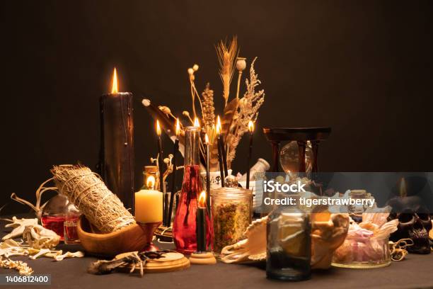 Occult And Esoteric Witch Doctor Still Life Selective Focus Halloween Background With Magic Objects Black Candles Skull Crystal Stones And Potions Vials On Witch Table Mystic Witchery With Weeds Stock Photo - Download Image Now