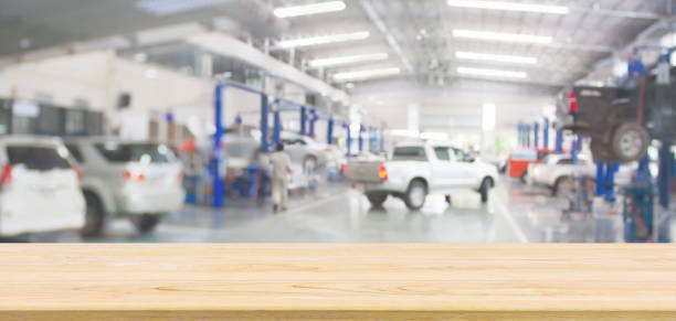 istock Empty wood table top with car service centre auto repair workshop blurred background 1406812587