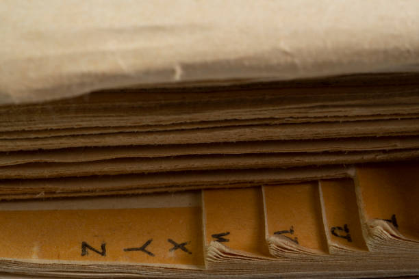 istock Old withered English dictionary book with alphabet side view macro close up. 1406812608