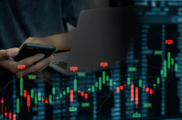 istock businessman using mobile phone and computer to find financial information. Candlesticks and graphs of the stock market economy.Virtual screen business concept. 1406813644