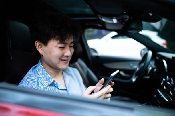 istock Asian young handsome man using smart phone in a car 1406816617