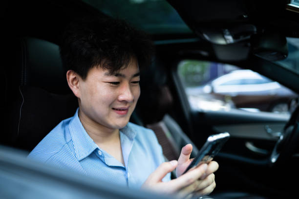 istock Asian young handsome man using smart phone in a car 1406816623