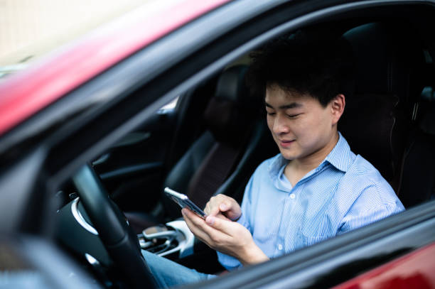 istock Asian young handsome man using smart phone in a car 1406816643