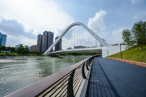 Riverside bridge and modern urban architecture in sunny days