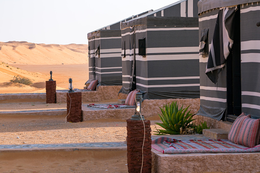 Wahiba Sands, Oman - 04.03.2018: Bedouin style camp with grey and white tents in Arabian desert. Adventure in Wahiba Sands desert. Travel Arabia