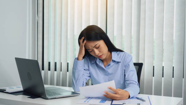 istock Asian woman manager is stressed and has a headache about faulty work documents at her office. 1406824281