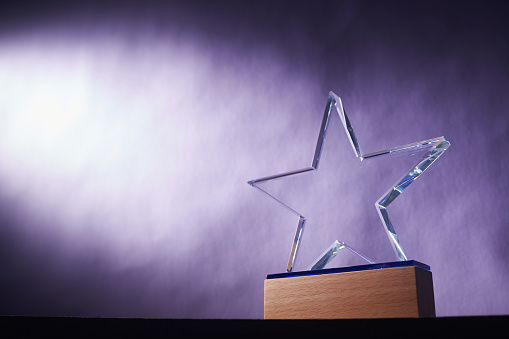 star shape of crystal trophy against purple background