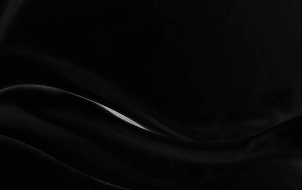 istock Black gray satin dark fabric texture luxurious shiny that is abstract silk cloth background with patterns soft waves blur beautiful. 1406828465