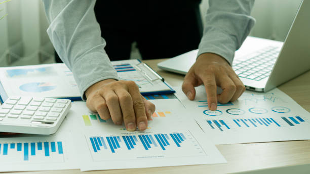 istock business people working with financial data hand holding pen pointing on charts annual business report analysis report using laptop at desk tax finance concept 1406829527