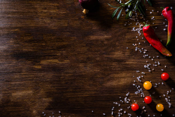istock Wooden dark background culinary theme copy space with champignon mushrooms, chilli peppers, hot peppers, salt, oil, vegetable oil, dill, greens, herbs, onions, cherry tomatoes, tomatoes. 1406834795