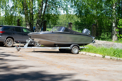 A boat or a boat with a motor on a trailer with wheels for transportation by car with a trailer.