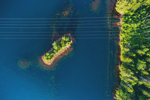 Looking down on high voltage transmission lines crossing a lake.