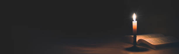 istock Banner image of Candle with bible on a old oak 1406840383