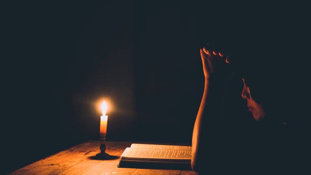 istock Woman praying in the light candles 1406840483