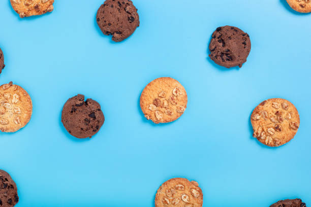 istock Chocolate cookies with chocolate, cookies with nuts on a blue background. Top view, flat lay. 1406840771