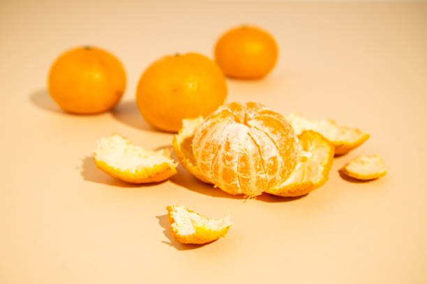 istock Fresh peeled orange mandarin close-up on a beige background. 1406842413