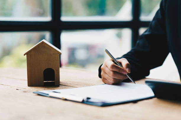 istock Signing House Rental Contract Document concept, House model with agent and customer discussing for contract to buy, get insurance or loan real estate or property. 1406842552