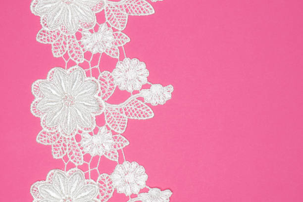 istock White laces with flowers and leaves on pink background isolated vertically 1406847839