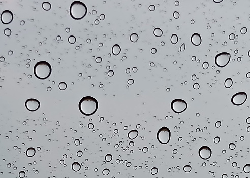 Raindrops on the car window form an aesthetic background