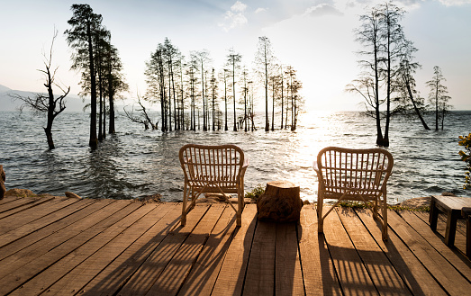 Wooden chairs on the lakeside.