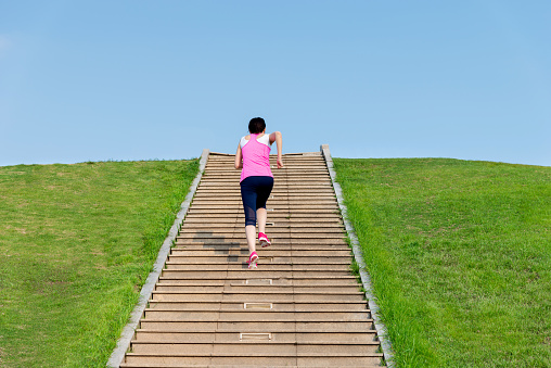 Woman running up the stairs in the park.