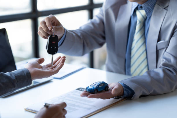 el vendedor de automóviles entregó las llaves a los clientes que firmaron el contrato de compra legalmente, finalización exitosa de las ventas de automóviles, contrato de compra y entrega de llaves. - car insurance sales occupation buying fotografías e imágenes de stock