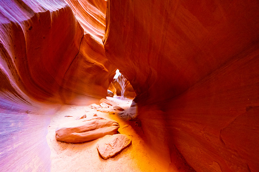 View along a hike inside the deep and narrow Antelope Canyon. This slot canyon is located near the city of Page in Arizona, USA. The walls are shaped like waves.