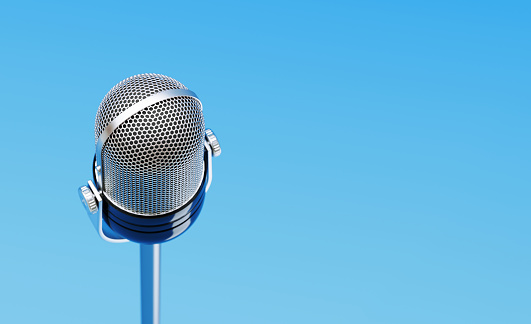 Microphone on blue background. Horizontal composition with copy space. High angle view.