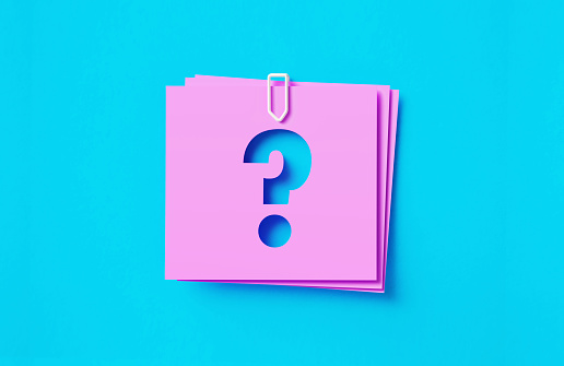 Question mark written cut out pink adhesive notes sitting on blue background. Horizontal composition with copy space.