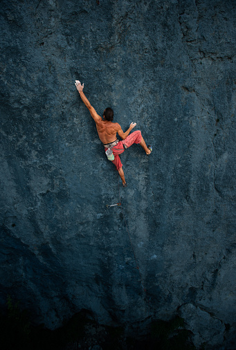 Muscular male climber on vertical wall face