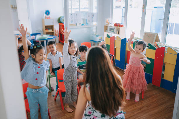 istock Asian Montessori preschool student raised hands in the class answering question 1406857177