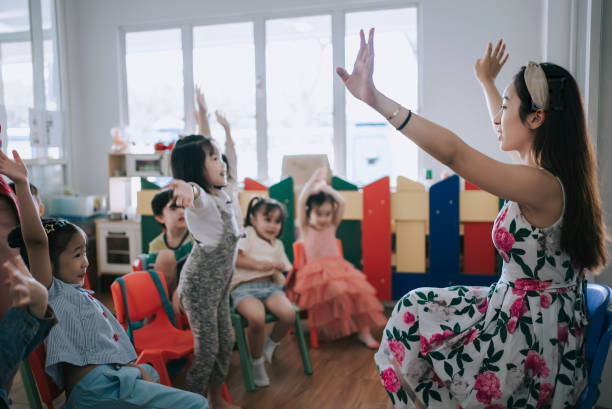 istock Asian Montessori preschool student raised hands in the class answering question 1406857187