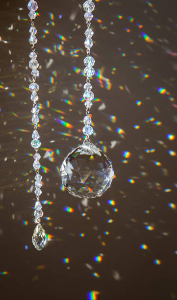 istock Selective focus on ball and teardrop shape crystal rainbow maker suncatcher hanging in home. Good Feng Shui, Sha Chi energy flow concept. Beautiful spring light in room. 1406857346
