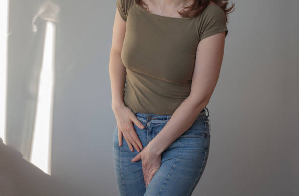 Woman holding hands on her crotch due to pain. Female health problems concept. Young woman holding hands between legs because of pain in bladder, PMS, periods. Candida symptoms. Girl is suffering from genital infection and holding hand on crotch. sti stock pictures, royalty-free photos & images