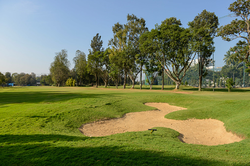A sand bunker in a golf course on a clear day