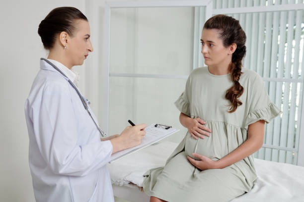 istock Doctor interviewing pregnant woman before treatment 1406860352