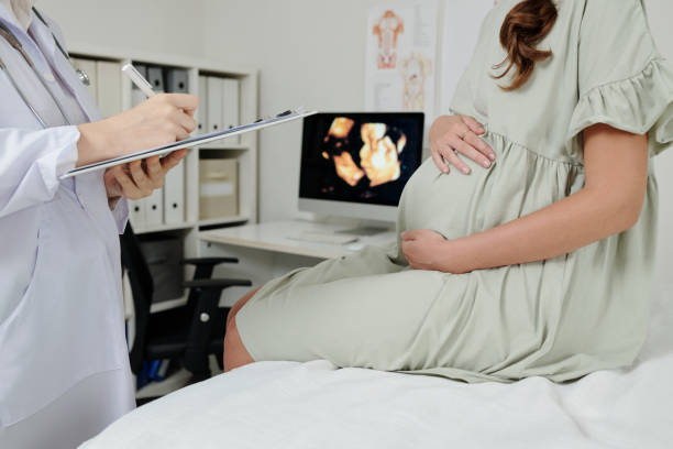 doctor making conclusion after ultrasound - doğum öncesi bakımı stok fotoğraflar ve resimler