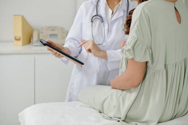 Doctors presenting information from tablet stock photo