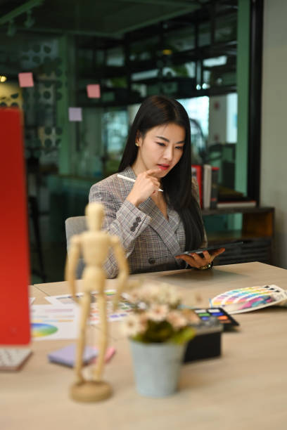 istock Concentrated female graphic designer using modern devices and working in her personal office. 1406861012