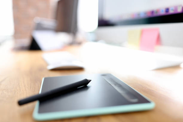 Graphic tablet and stylus on designer desktop. Work and photo processing concept