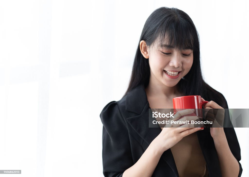 portrait of young successful businesslady on a coffee break, she is resting and enjoying the drink. Woman is on a white background. Adult Stock Photo