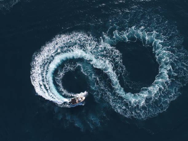 vista aérea de um barco de prazer branco em um dia de verão. powerboat gira loop oito no mar fazendo conceito de infinito metaverso conceito futuro. - recreational boat motorboat speedboat aerial view - fotografias e filmes do acervo