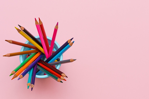 Colored wooden pencils on pink background, education concept