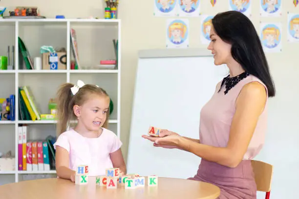 developmental and speech therapy classes with a child-girl. Speech therapy exercises and games with letters. dice game