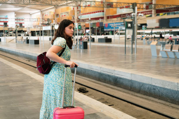 istock Woman with suitcase in a railroad station 1406868277